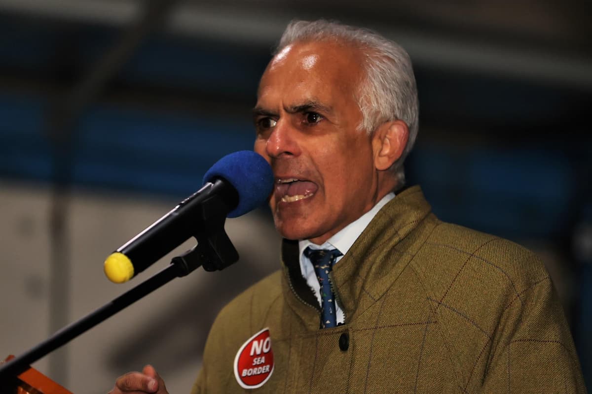 Ben Habib giving a passionate speech on stage, gesturing emphatically to the audience.
