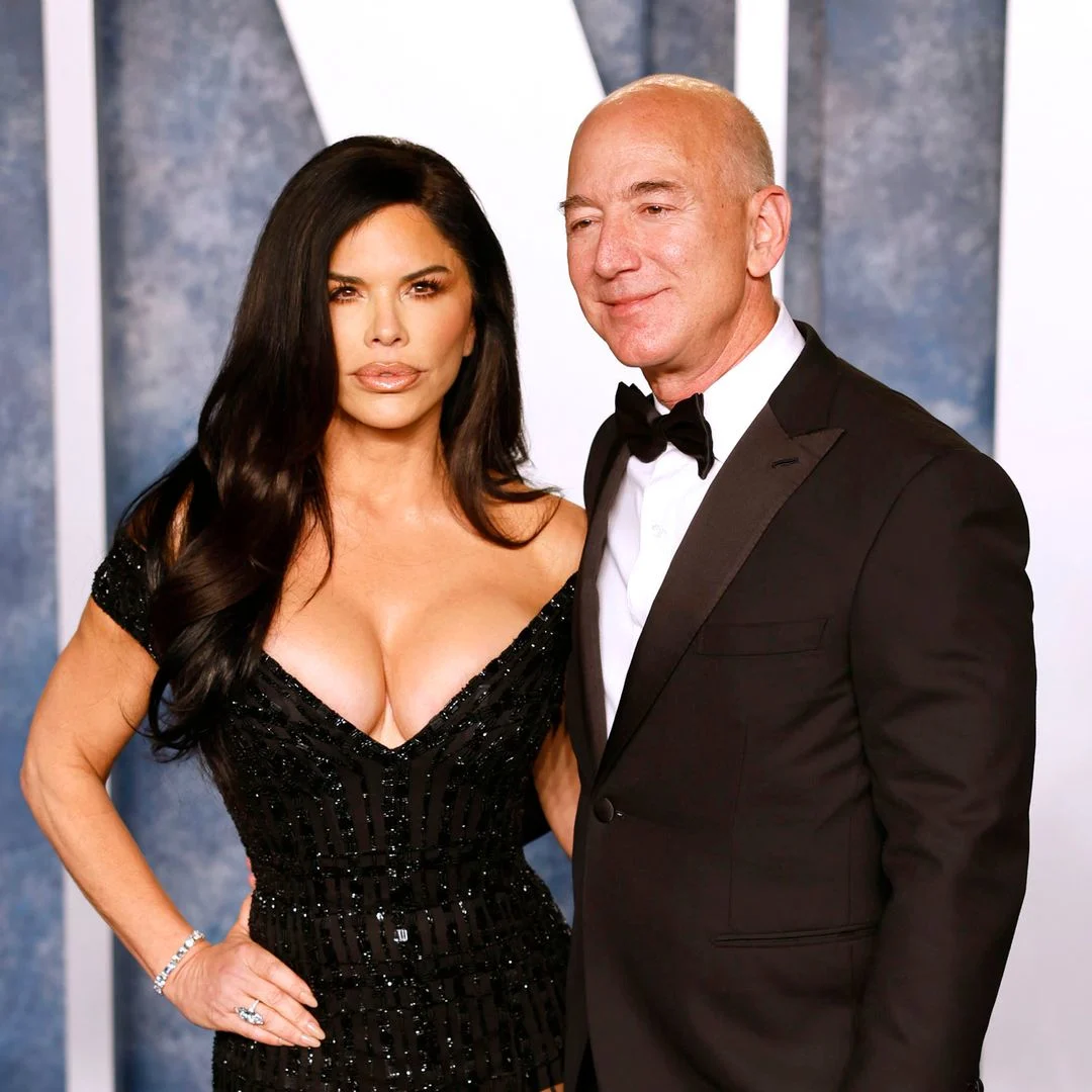 Jeff Bezos and Lauren Sanchez posing together on the red carpet, dressed elegantly for a high-profile event.