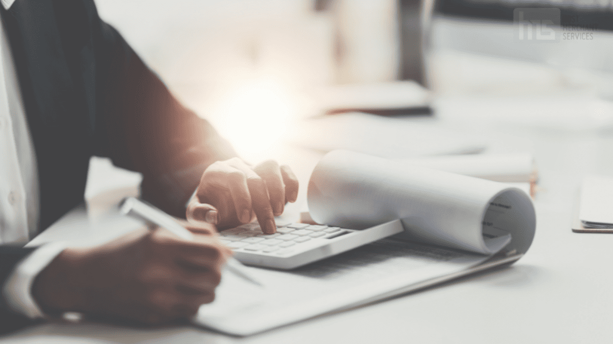 A businessman working with documents and a calculator while preparing a detailed business loan proposal, illustrating careful financial planning.