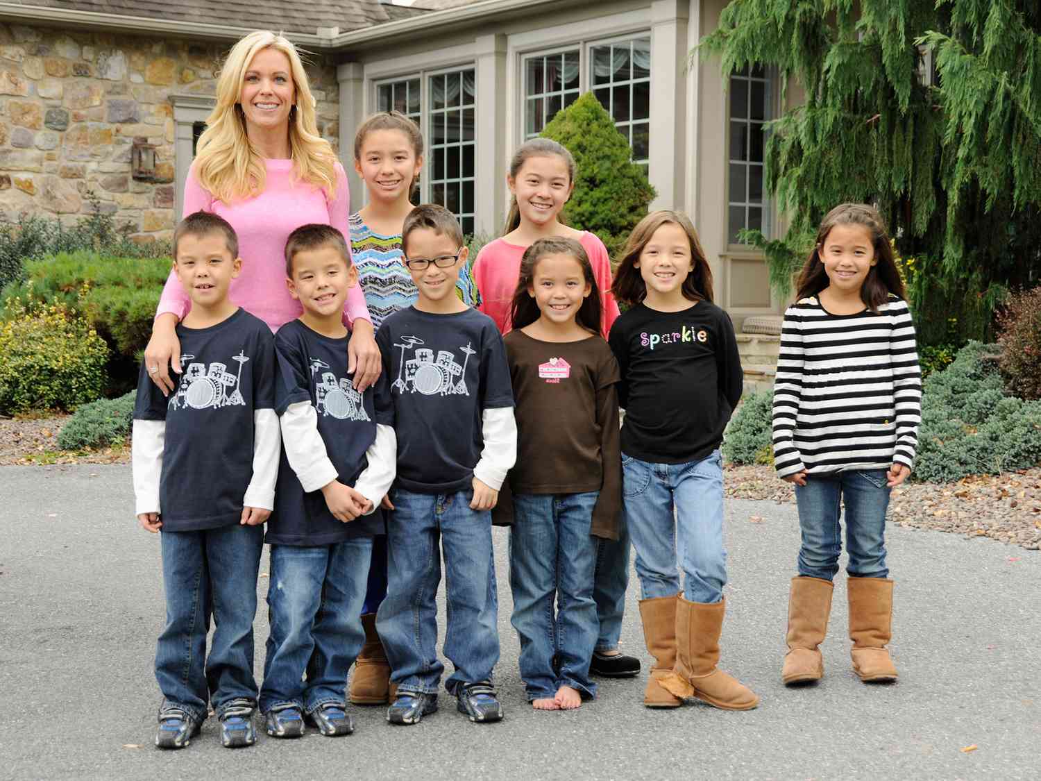 Kate Gosselin posing with her eight children, smiling together as a family.