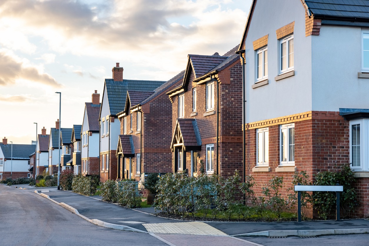 houses in england with typical red bricks at sunset main street in a new estate with typical british houses on the side real estate and buildings concepts in uk