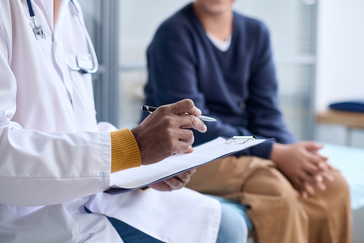 doctor holding clipboard consulting child