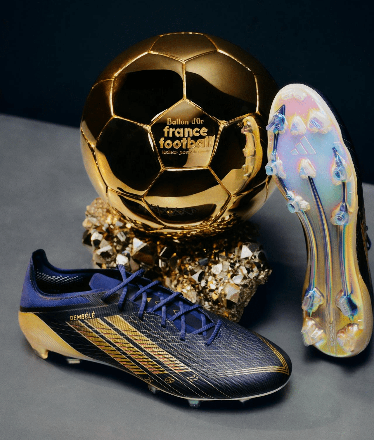 Adidas F50 Ballon d’Or 2025 boots designed for Ousmane Dembélé, displayed alongside his Ballon d’Or trophy.