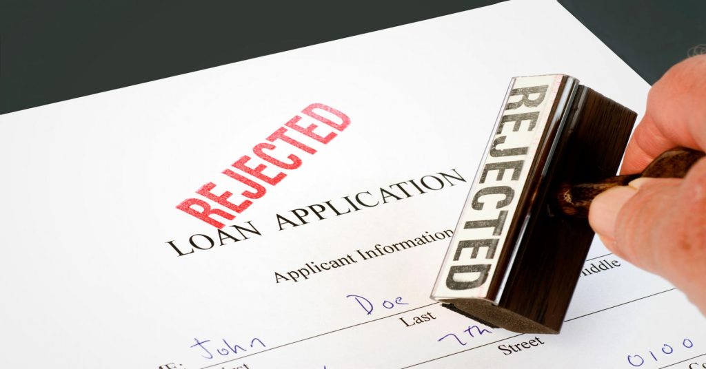 Business loan documents with a red “REJECTED” stamp, symbolizing a declined small business loan application in the US.