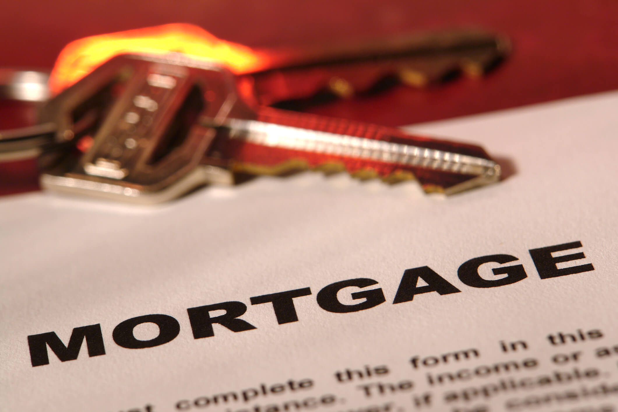 A mortgage document with a set of house keys placed on top, symbolizing home ownership and loan approval.
