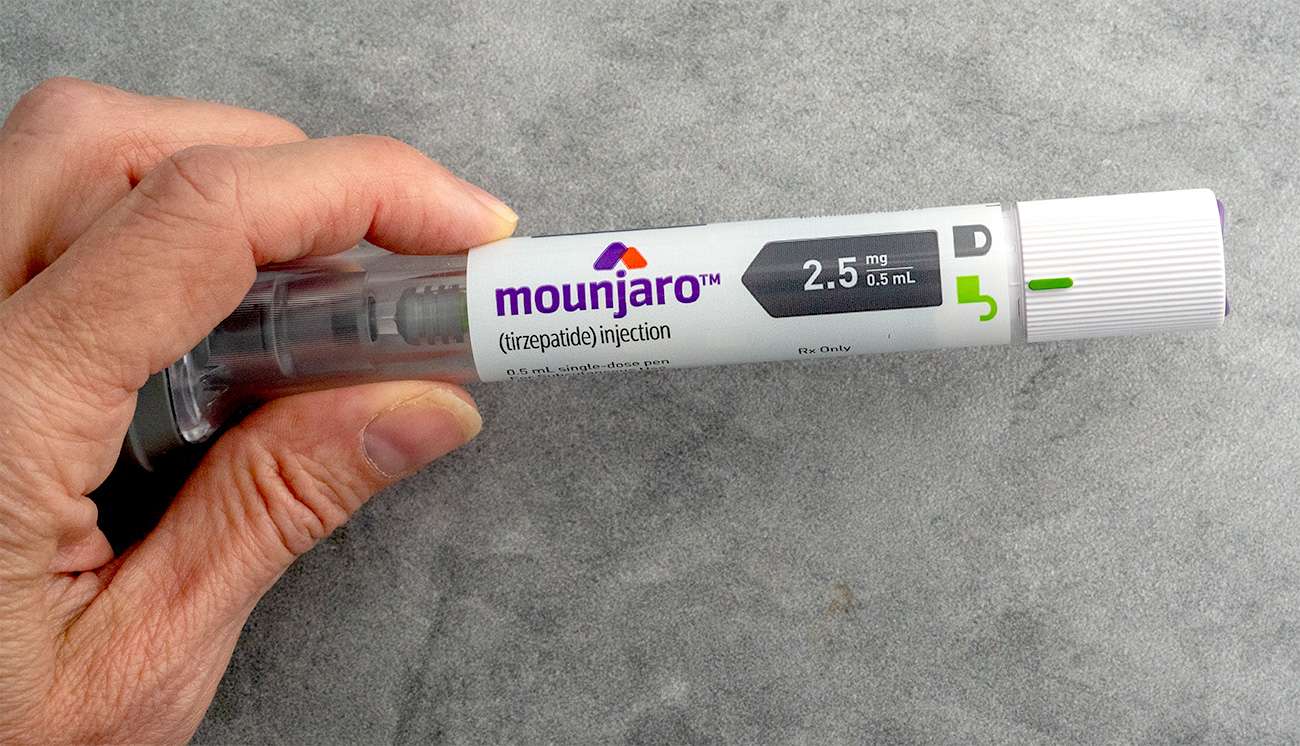 Person holding a Mounjaro injection pen, highlighting a competitor in the weight-loss drug market.