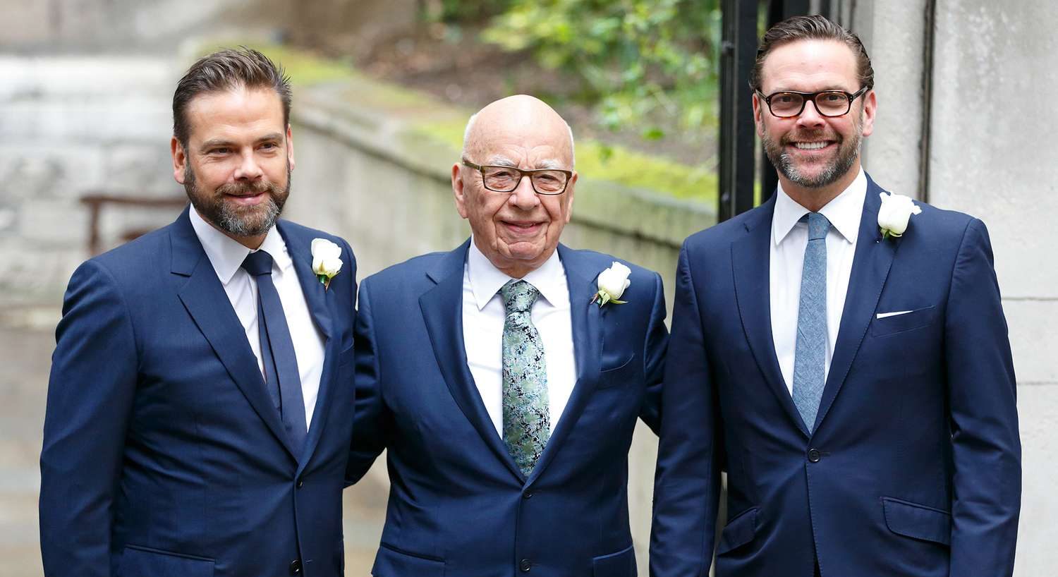 Rupert Murdoch in a dark suit standing alongside his sons James Murdoch and Lachlan Murdoch at a formal event.