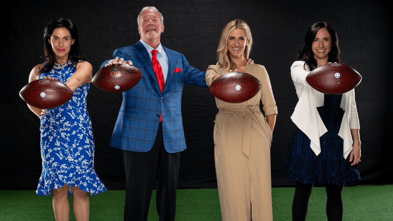 Jim Irsay and his daughters—Carlie, Casey, and Kalen—pose together holding NFL footballs during a family-themed photoshoot.
