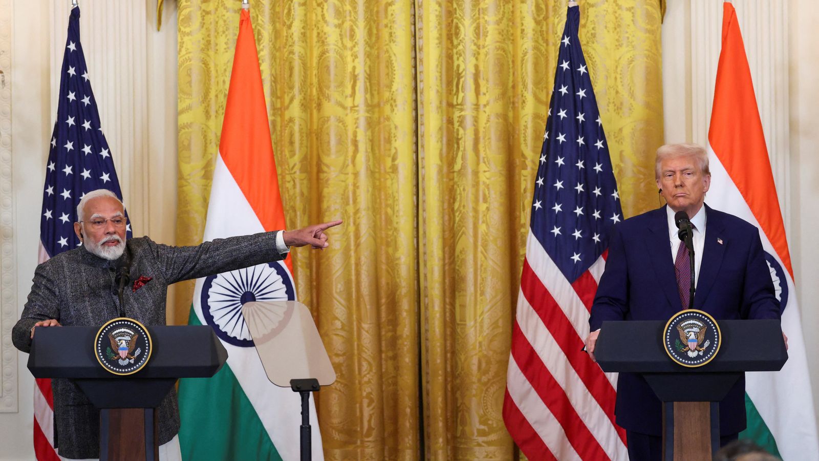 U.S. President Donald Trump and Indian Prime Minister Narendra Modi standing at podiums during a joint press conference, with Modi gesturing toward Trump.