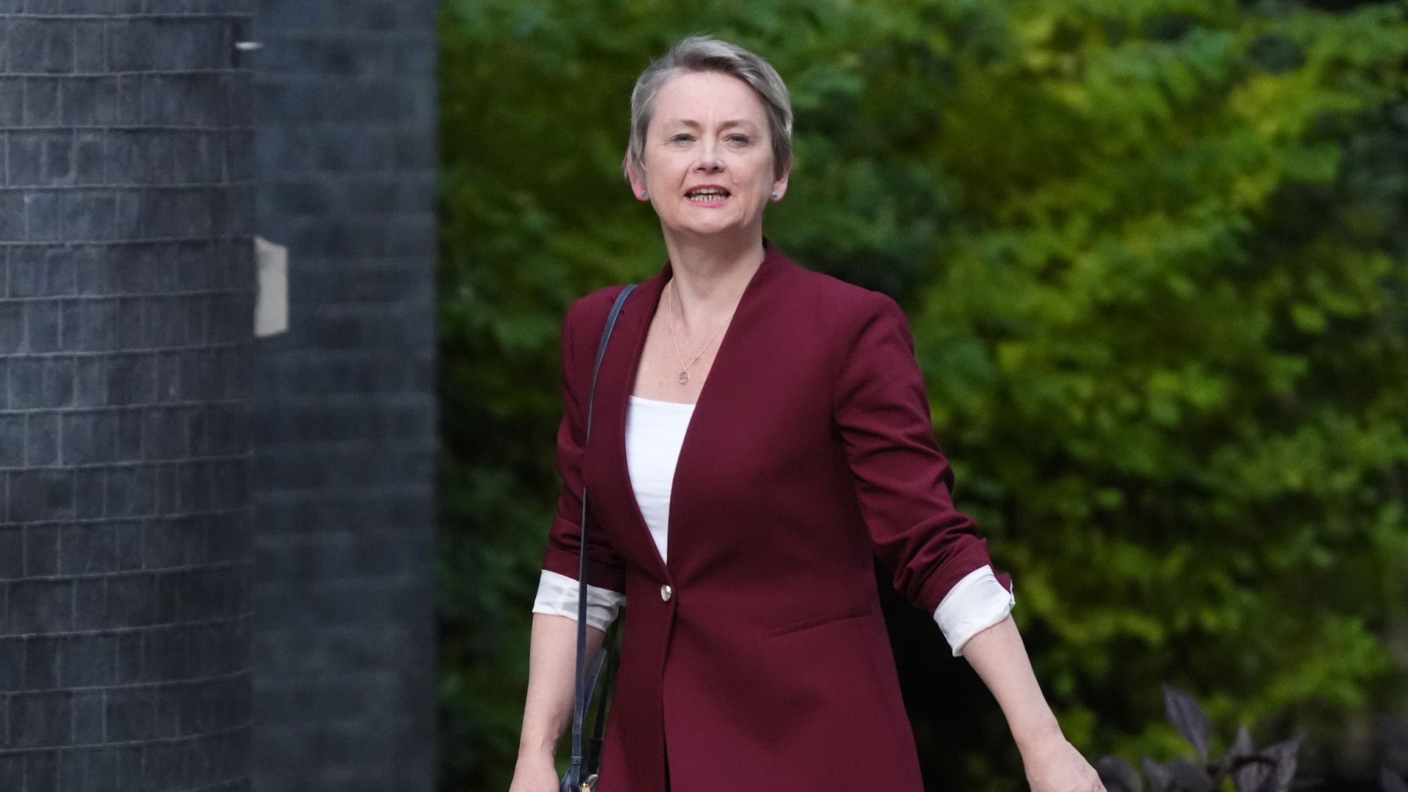 Yvette Cooper smiling at the camera while walking down Downing Street.