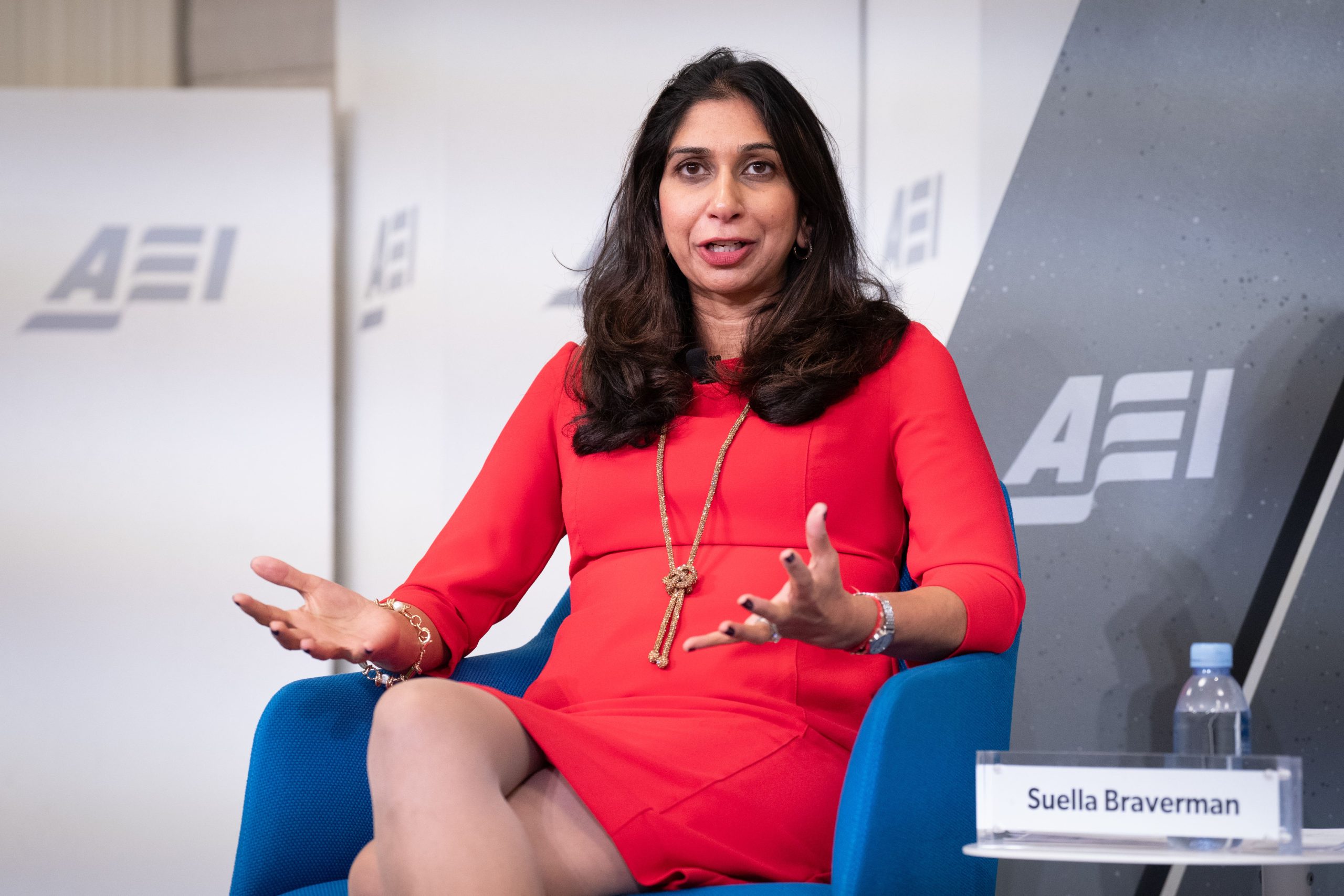Suella Braverman seated on stage, engaging with an audience during a public speaking event.