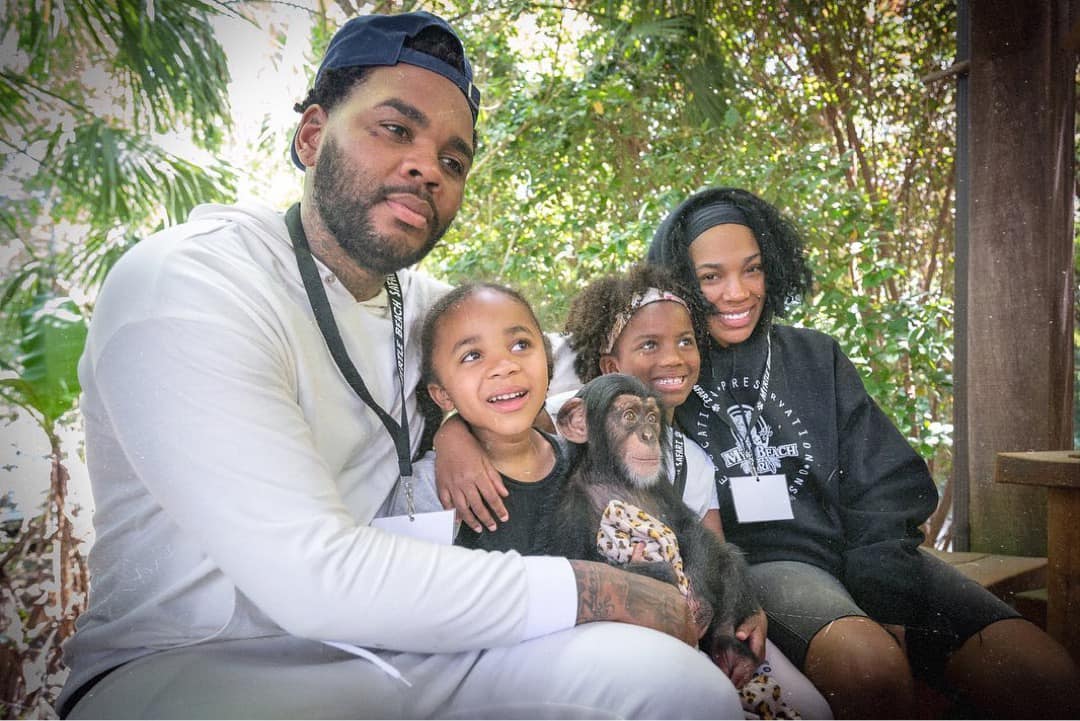 Kevin Gates and Dreka Gates pose with their children in a park, smiling and enjoying family time outdoors.