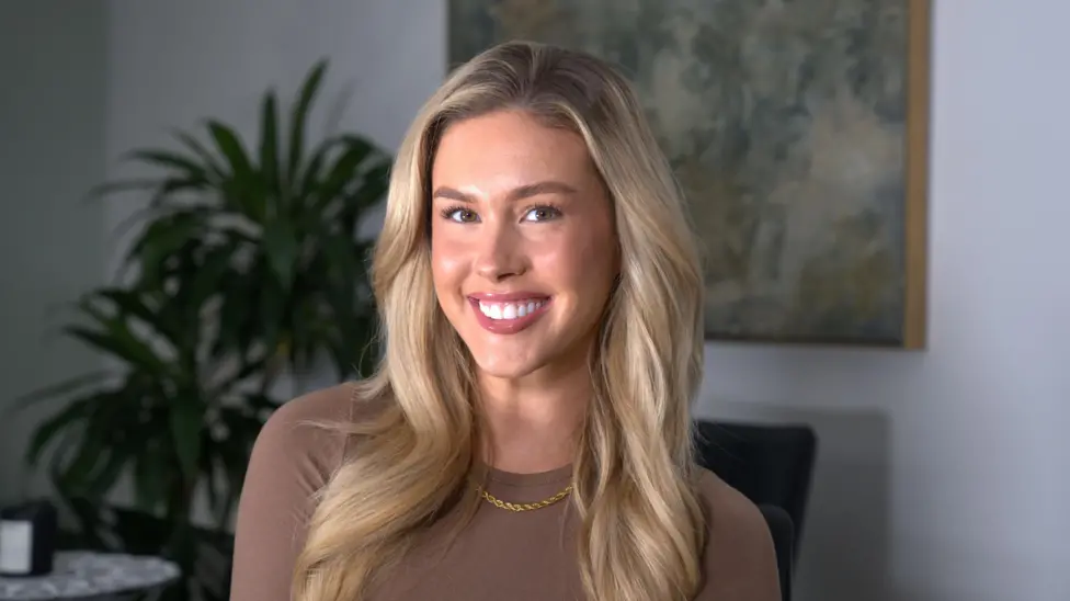 Ellie Jackson smiling at her desk in a modern office setting.