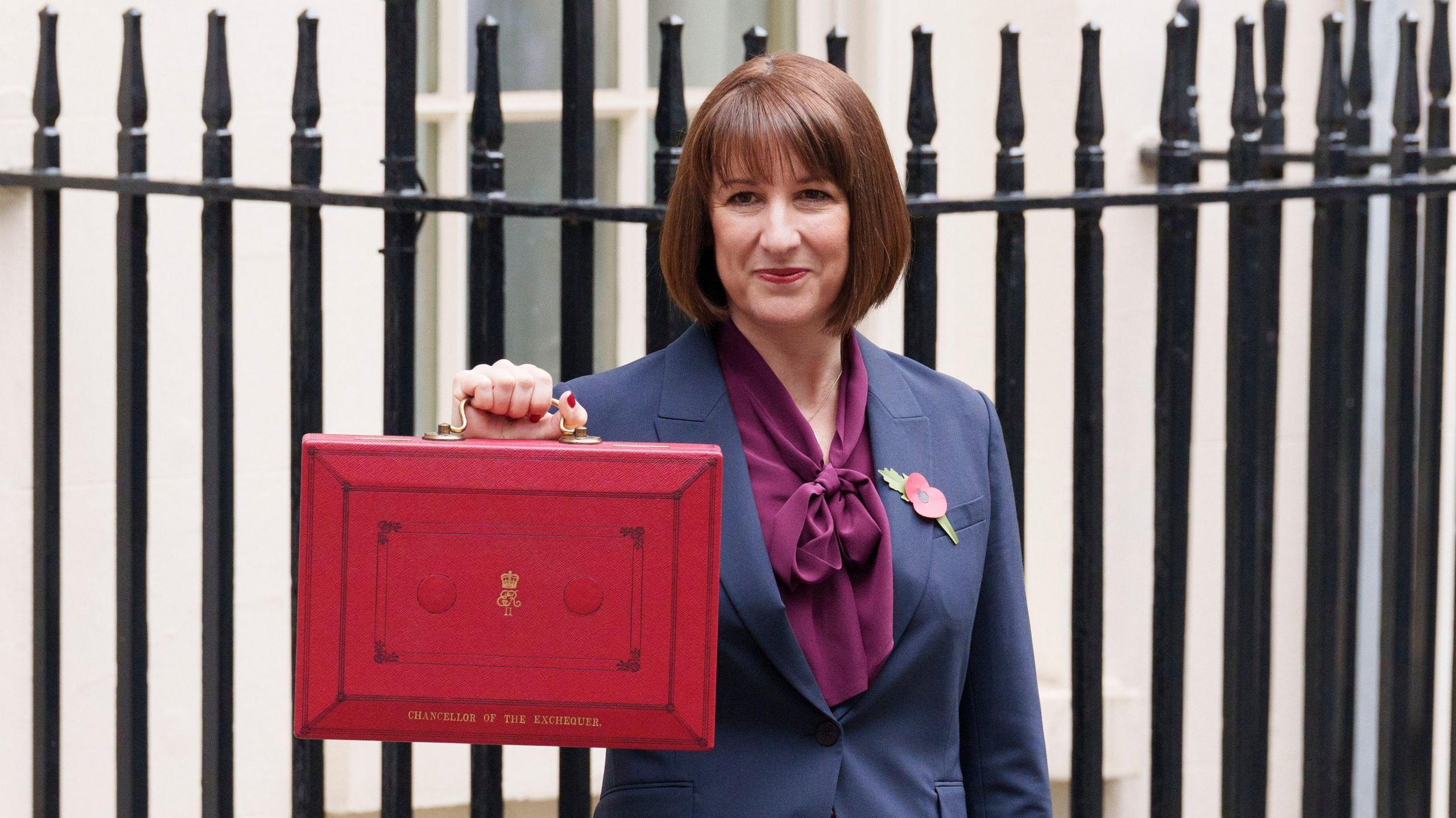 Rachel Reeves, UK Chancellor of the Exchequer, holds the traditional red Budget Box outside Downing Street ahead of the 2025 Budget announcement.