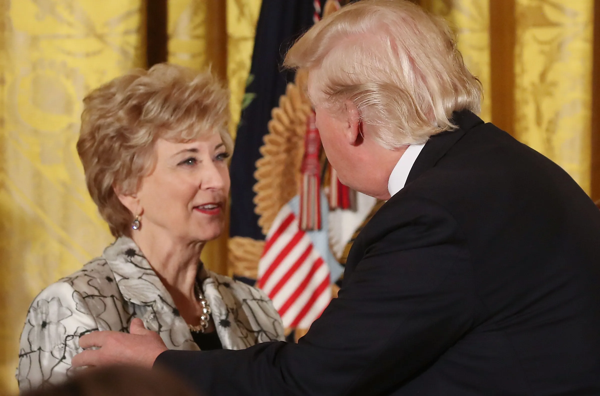Donald Trump and Education Secretary Linda McMahon embrace on stage after announcing the renewed student loan forgiveness deal.