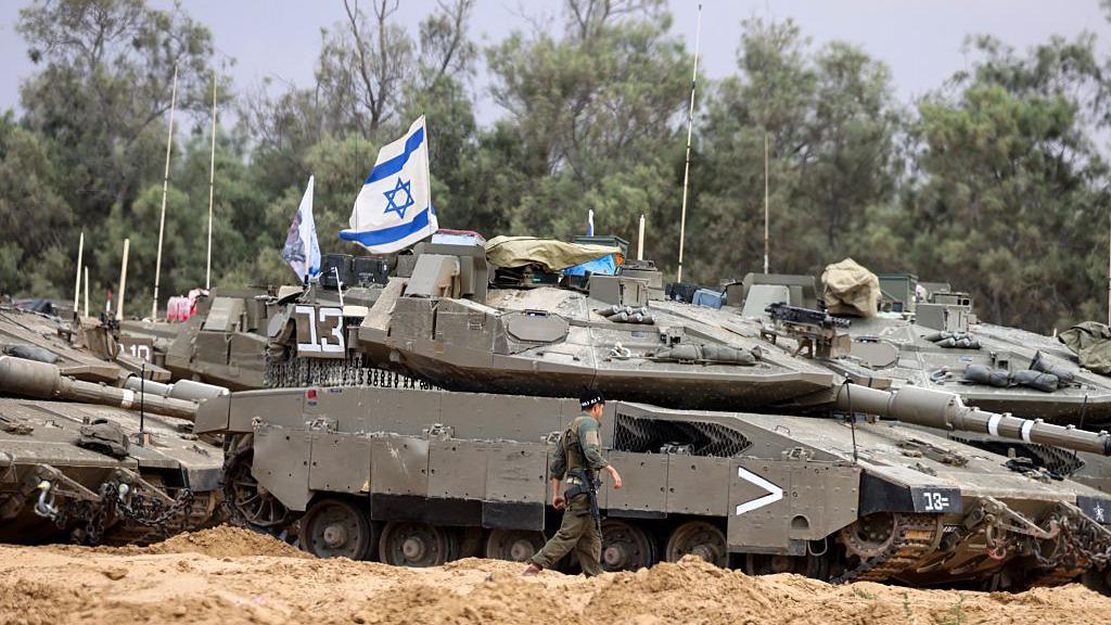 Israeli tanks and fighter jets deployed in Gaza, with smoke rising in the background and destroyed buildings visible on the ground.