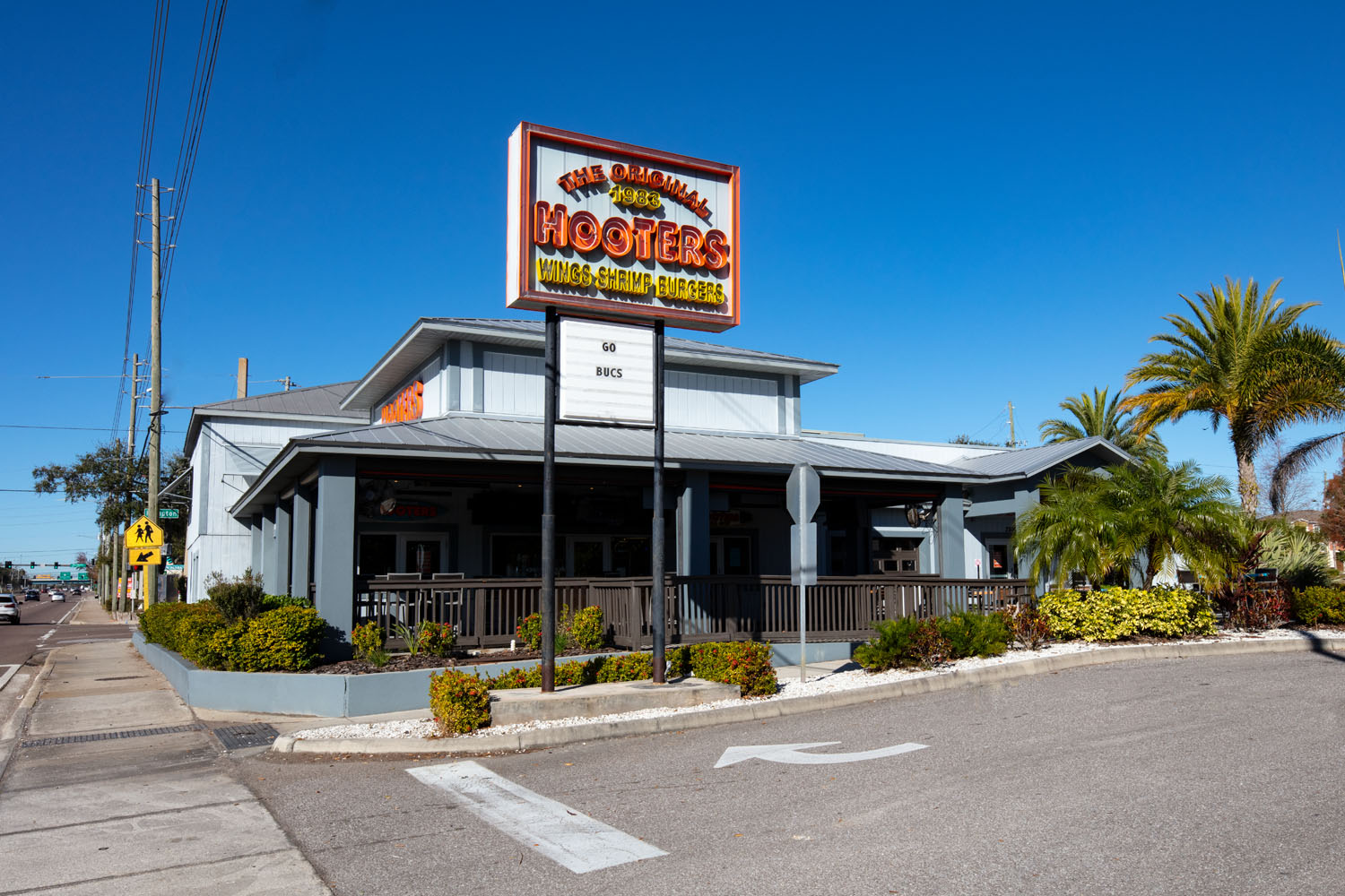 Exterior of the first-ever Hooters restaurant in Clearwater, Florida, featuring its classic wood-paneled façade and iconic signage.
