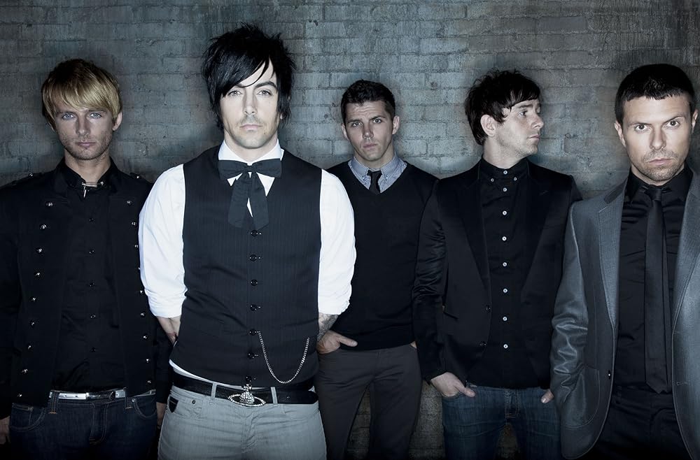 The members of Lostprophets performing together on stage during the peak of their career, captured in an energetic live performance.