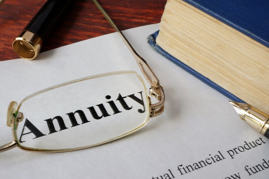 Close-up of an annuity contract with a pen and reading glasses resting on top, symbolizing careful financial planning.