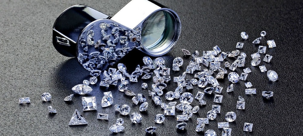 Loose diamonds scattered on the ground, spilled during a high-value jewellery heist, glinting under light.