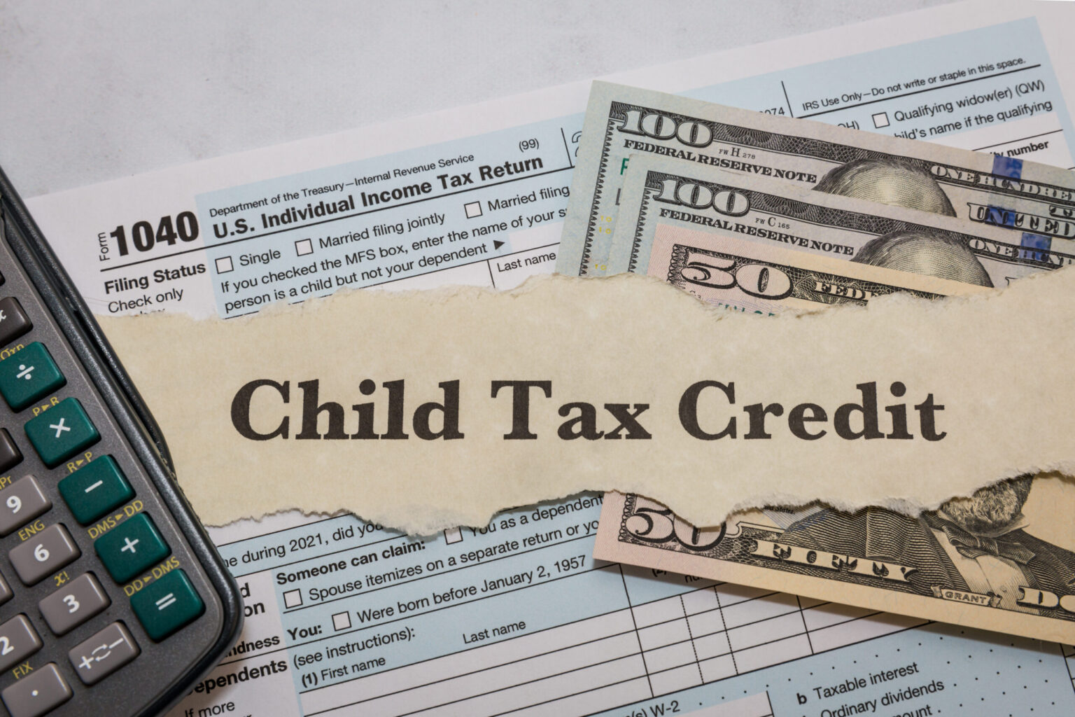 Child Tax Credit paperwork on a desk with a calculator, cash, and documents.