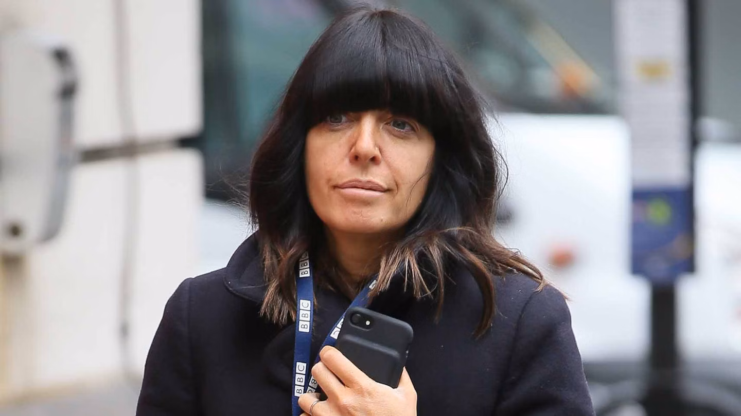 Claudia Winkleman attending an Anya Hindmarch London event, wearing her signature dark hair and fringe with a tailored grey jacket.