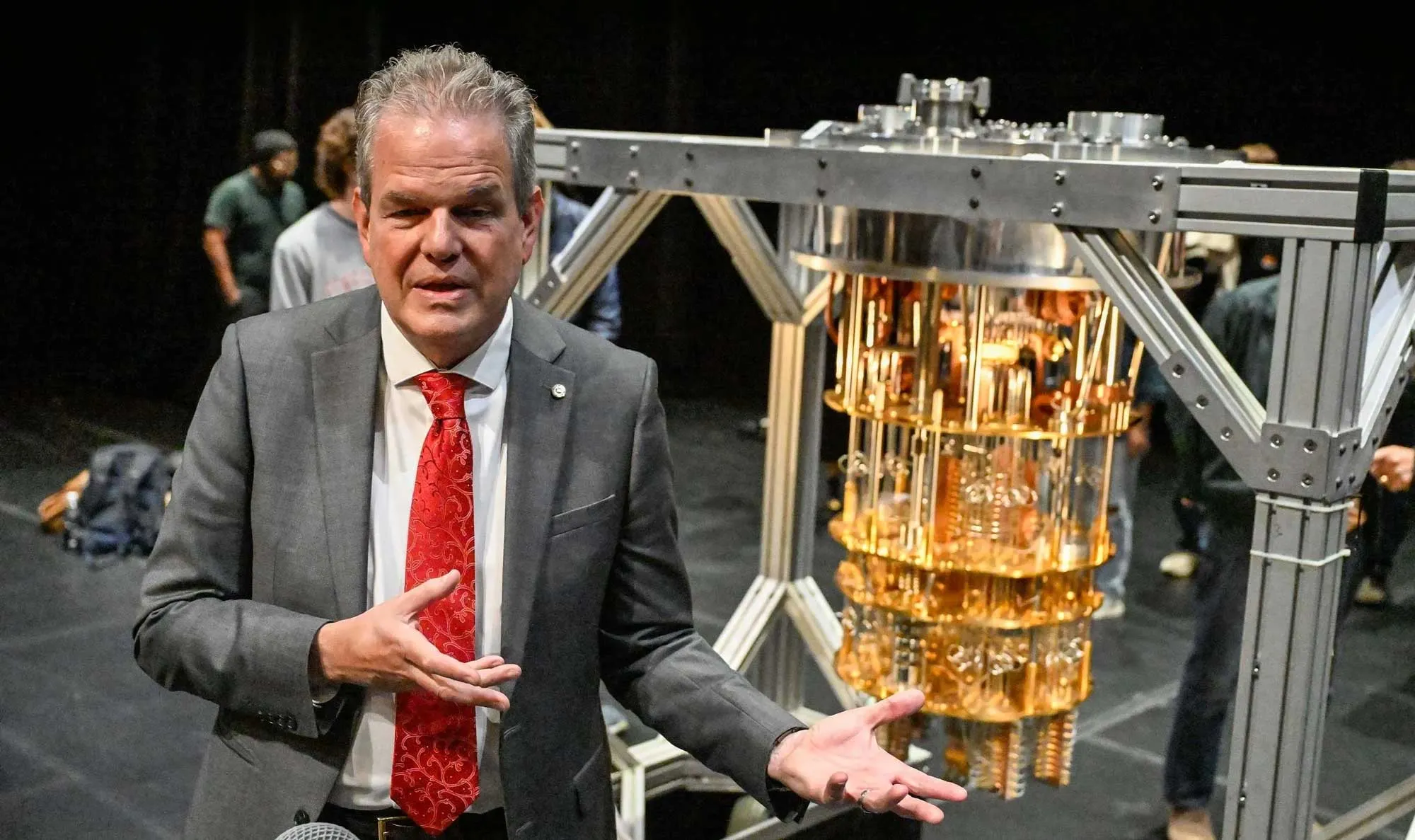 Curtis Priem wearing a dark suit, standing confidently while presenting an engineering project.