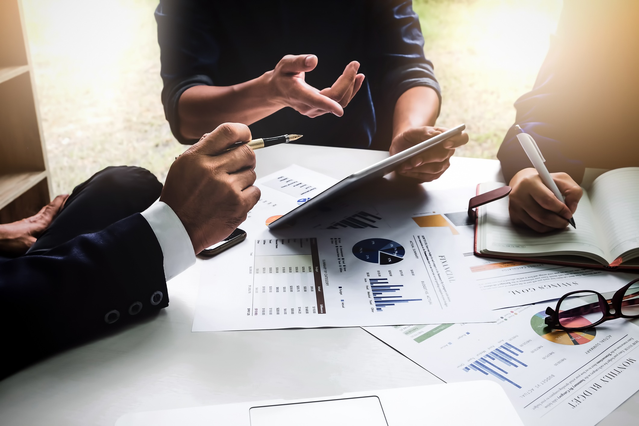 business people using pen,tablet,notebook are planning a marketing plan to improve the quality of their sales in the future.