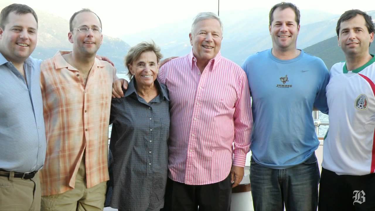 Robert Kraft with his first wife Myra Hiatt and their four sons posing in front of their boat, smiling and dressed casually.
