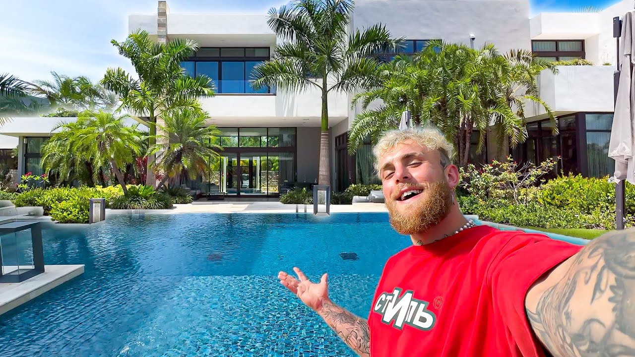 Jake Paul posing by the pool of his $16 million luxury mansion, showcasing the property’s modern design and waterfront amenities.