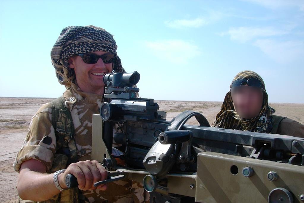 Tom Tugendhat manning a mounted gun during his military service in Iraq, wearing full combat gear.