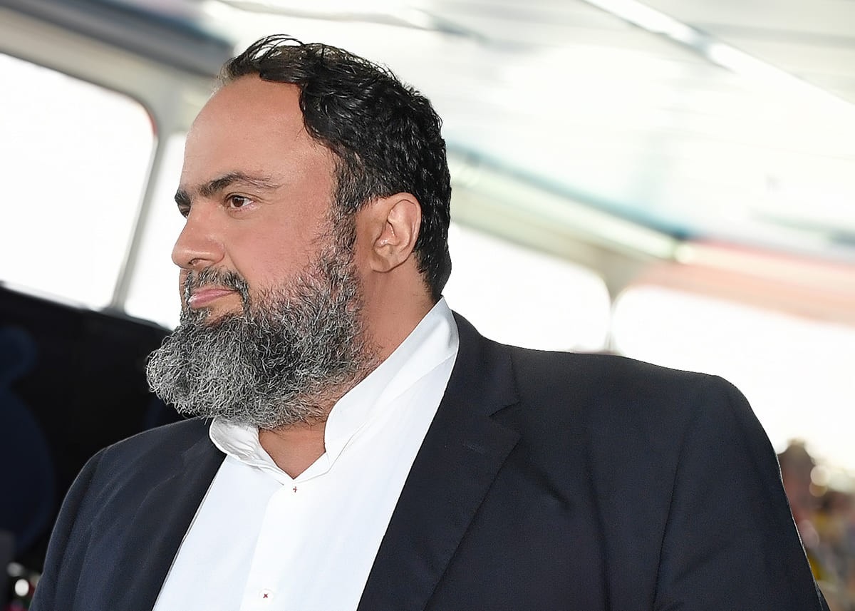 Evangelos Marinakis aboard one of his commercial ships, overlooking the deck that symbolizes the foundation of his global shipping empire.