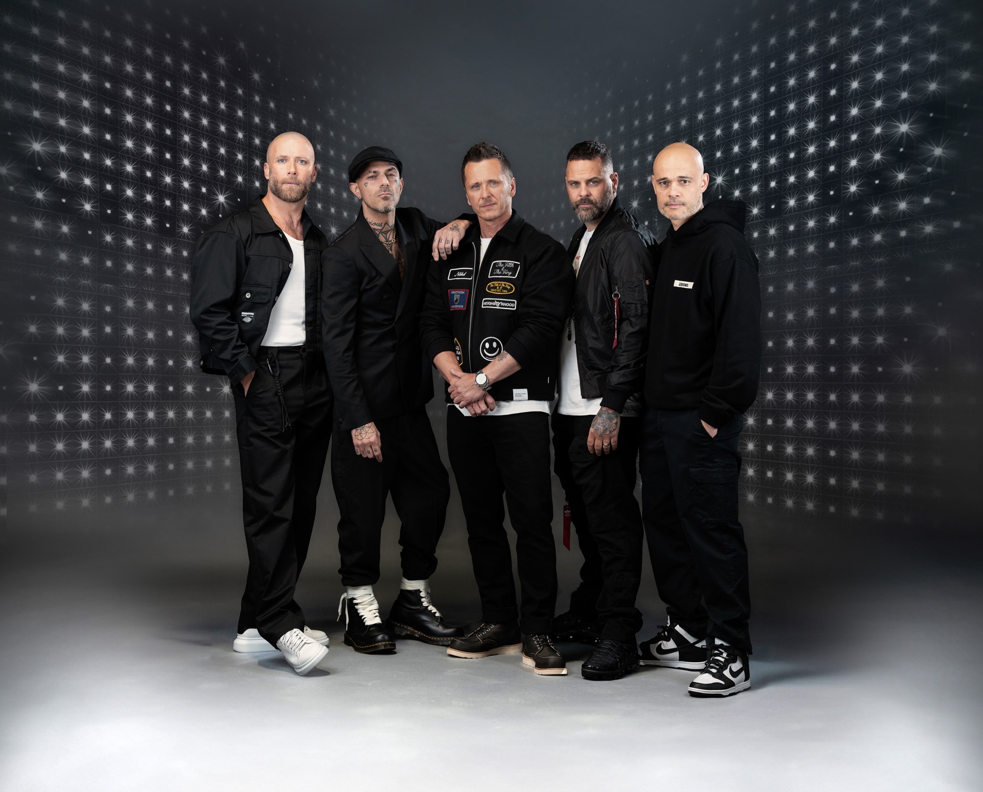 Five posing together during a 2025 tour photoshoot, dressed stylishly and showcasing their reunited energy.