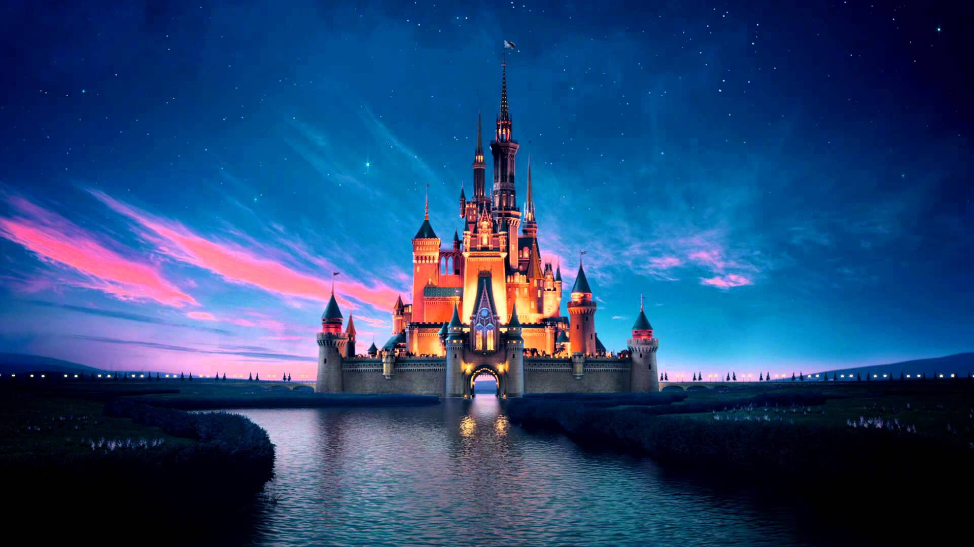 The iconic Disney castle at a theme park, brightly lit against the sky