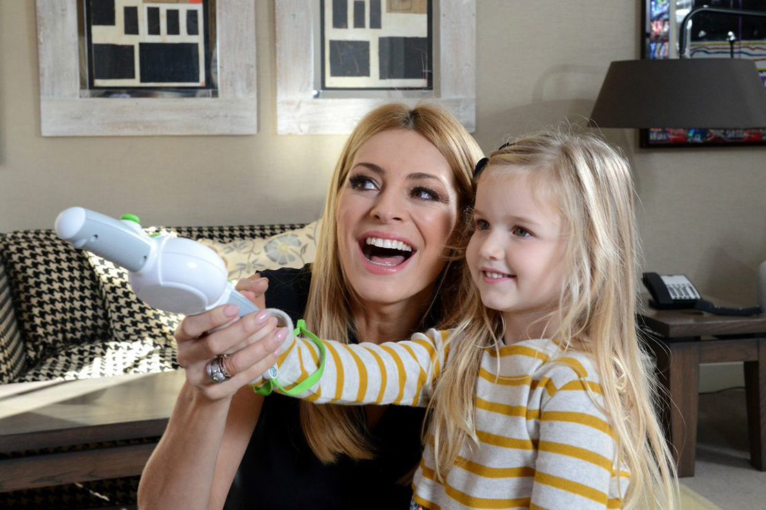 Tess Daly plays with her daughter in their cozy living room, surrounded by soft lighting and family decor.