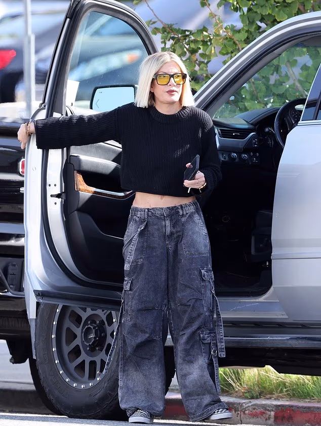 Tori Spelling stepping out in Los Angeles for the first time since finalizing her divorce from Dean McDermott, wearing a black cropped sweater and cargo pants.