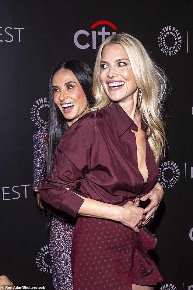 Demi Moore and Ali Larter hug and laugh together on the red carpet at the Landman season two premiere in New York City, looking joyful and glamorous.