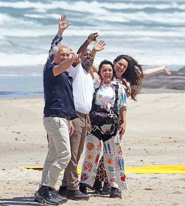 Kelly Brook, Martin Kemp, Aitch, Shona McGarty, and Eddie Kadi celebrate together on Broadwater Beach after parachuting in for the I’m A Celebrity 2025 launch.