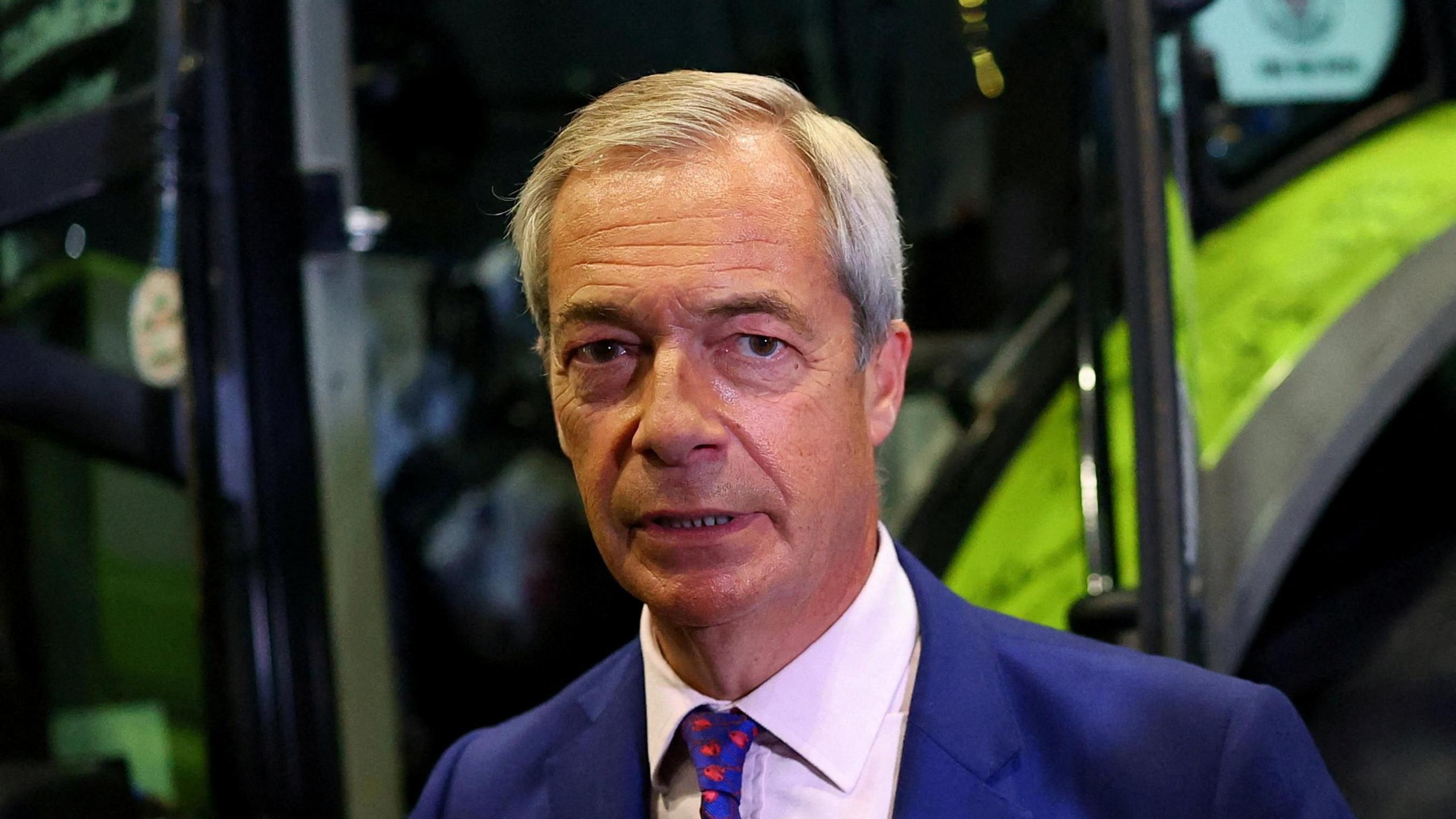 Nigel Farage looking shocked and uneasy, resembling a “rabbit in headlights,” as media scrutiny and public criticism intensify around the school racism allegations.