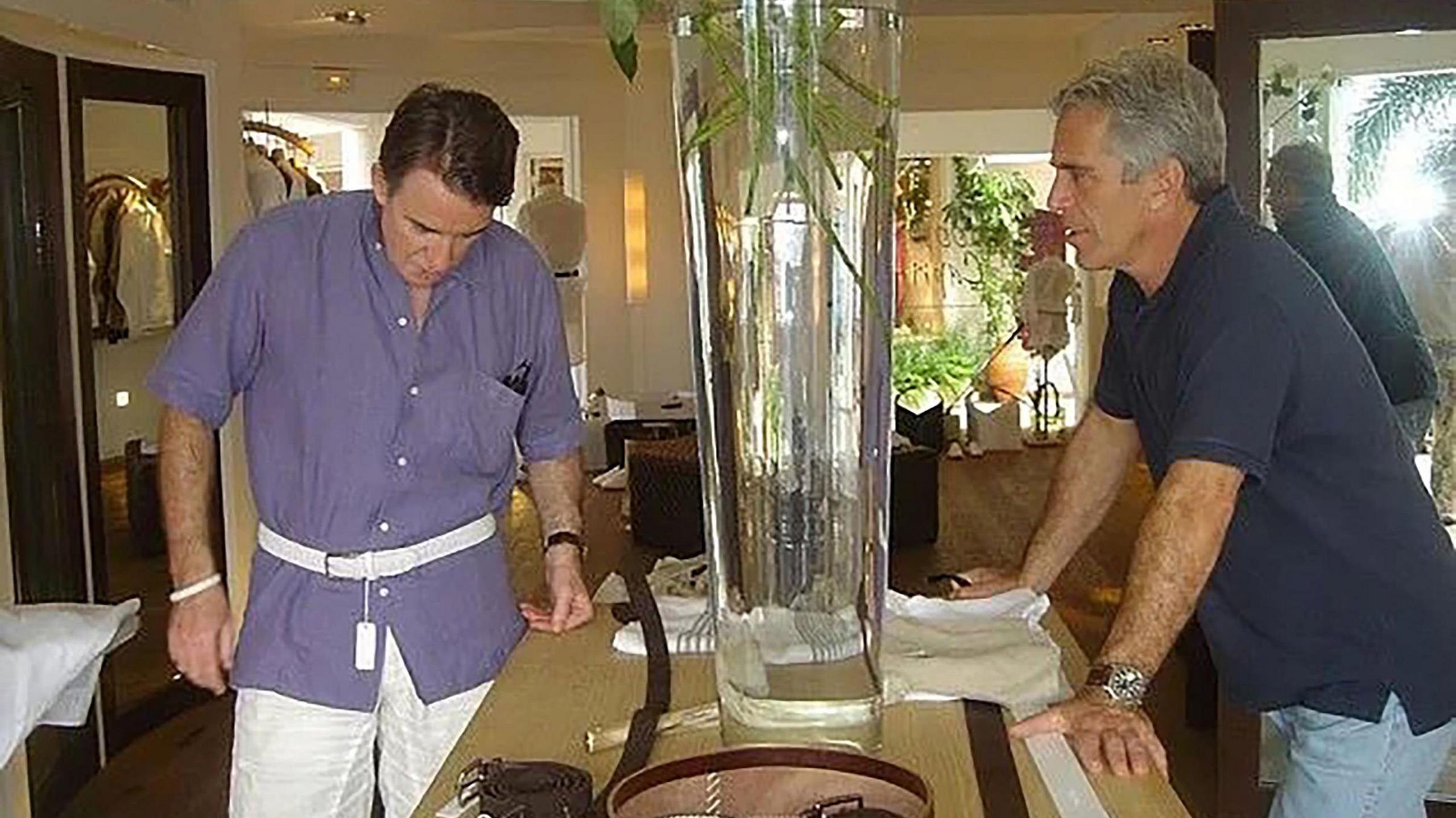 Jeffrey Epstein and Peter Mandelson sit together on Epstein’s private island, about to have breakfast, highlighting their controversial association.