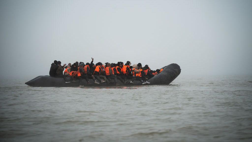 A small boat carrying migrants illegally crossing the English Channel in calm waters.