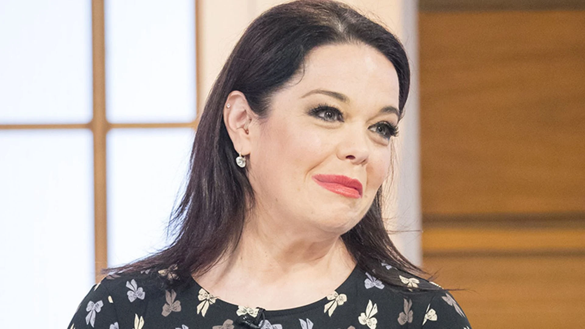 Lisa Riley smiling brightly while appearing on a morning television talk show.