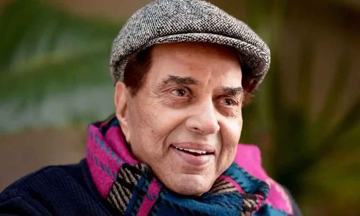 Dharmendra smiling warmly outdoors, dressed casually, with natural light highlighting his face.