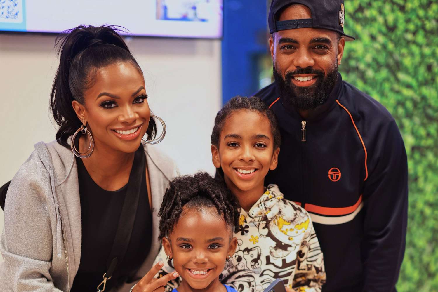 Kandi Burruss and Todd Tucker smiling with their children, Ace and Blaze, posing for a family photo.