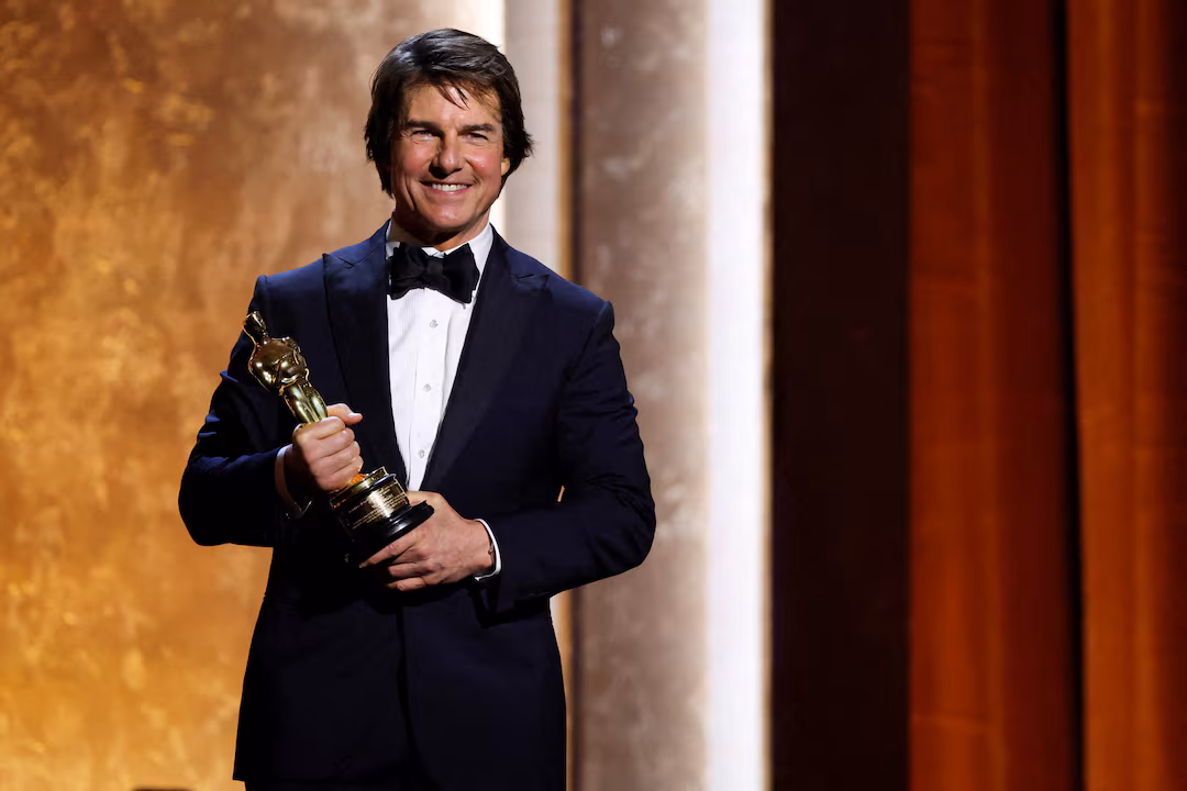 Tom Cruise on stage holding his first Oscar statuette at the Governors Awards, celebrating his lifetime achievements in film and the financial boost it brings to his career.