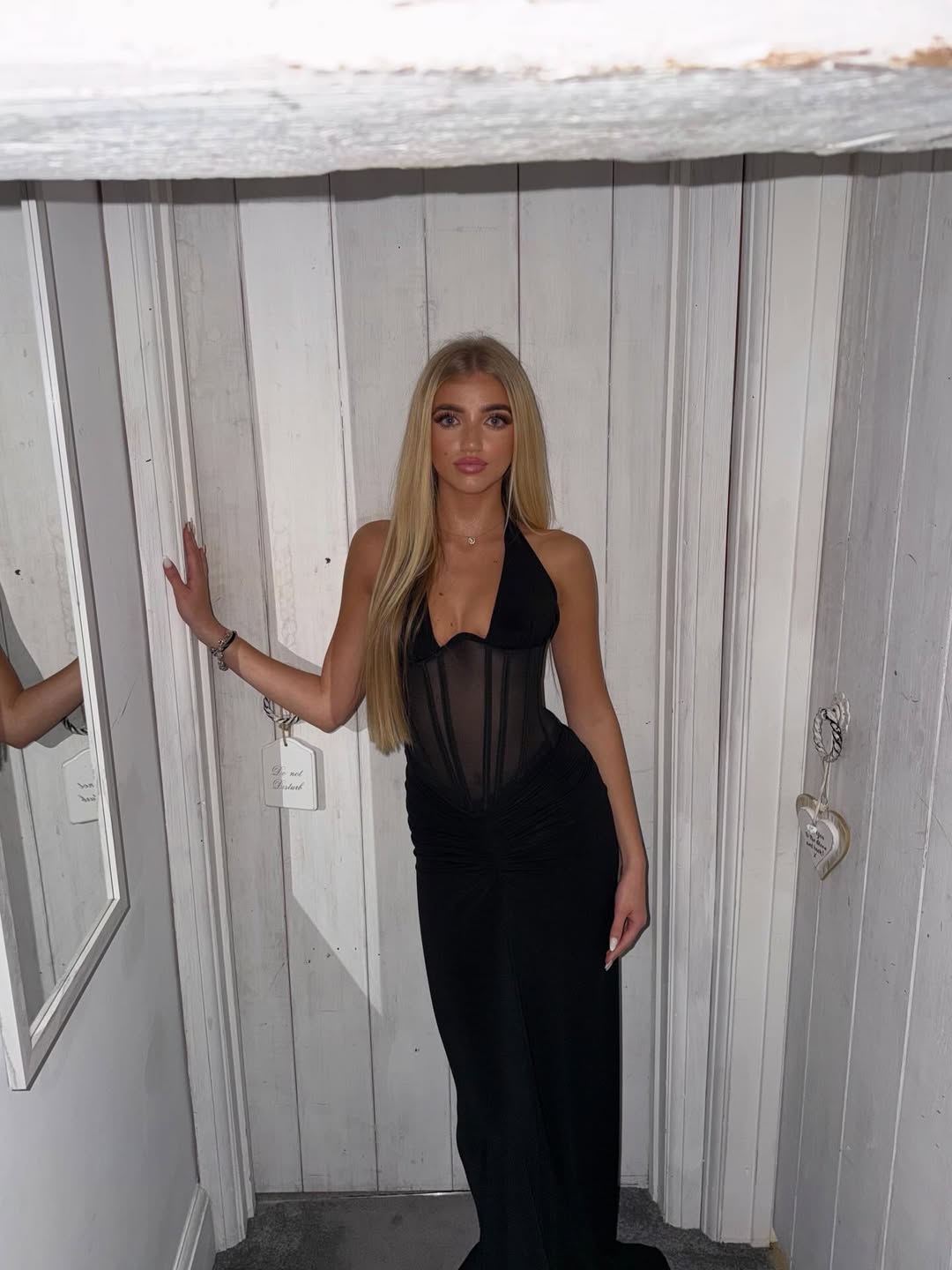Full-length image of Princess Andre posing in a sleek black gown for her Instagram post, showing the elegant, figure-hugging design and sheer panel detailing.