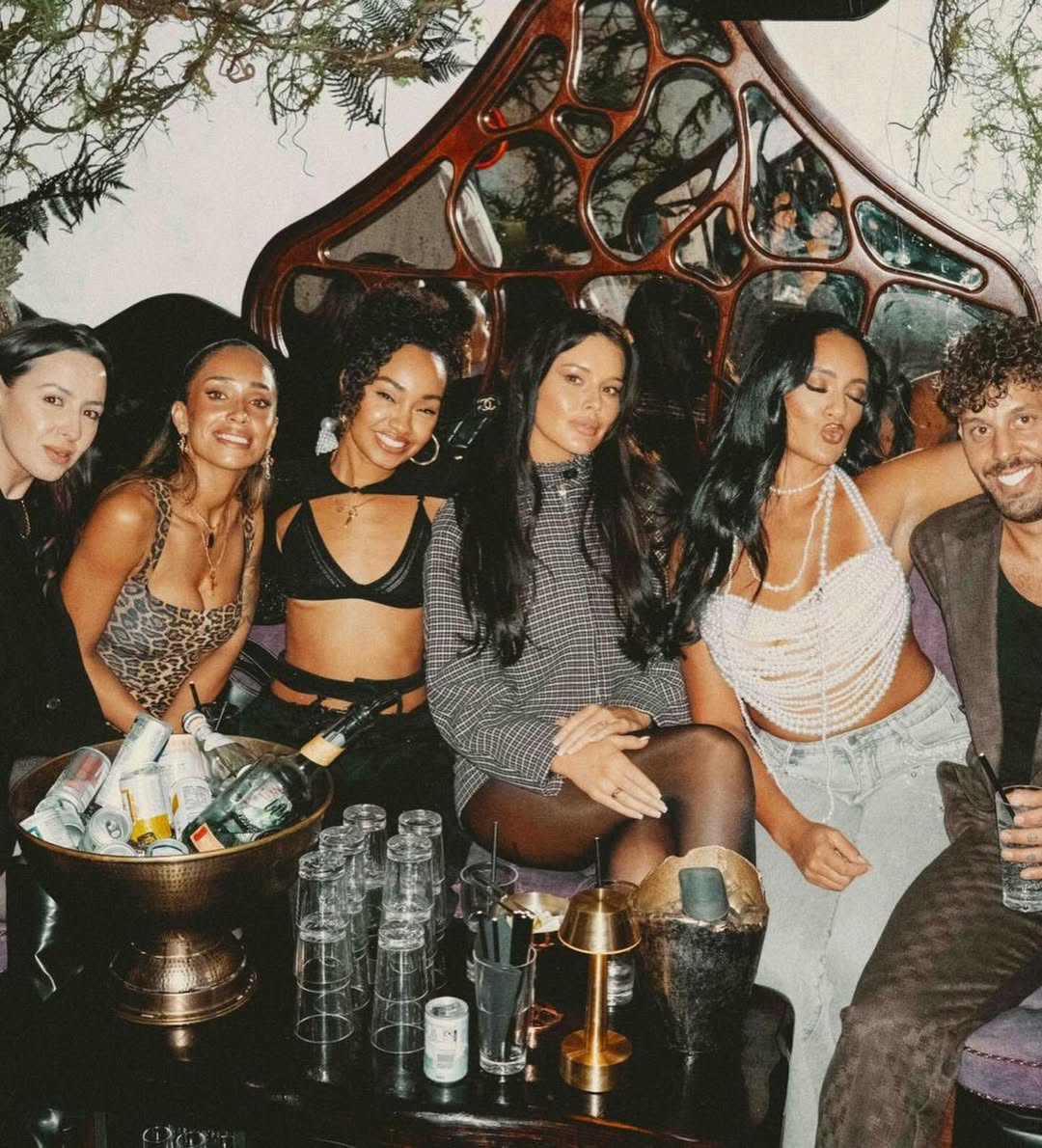 Leigh-Anne Pinnock poses with friends during their night out, all smiling and dressed up, with Leigh-Anne standing center in her black bra-top outfit.