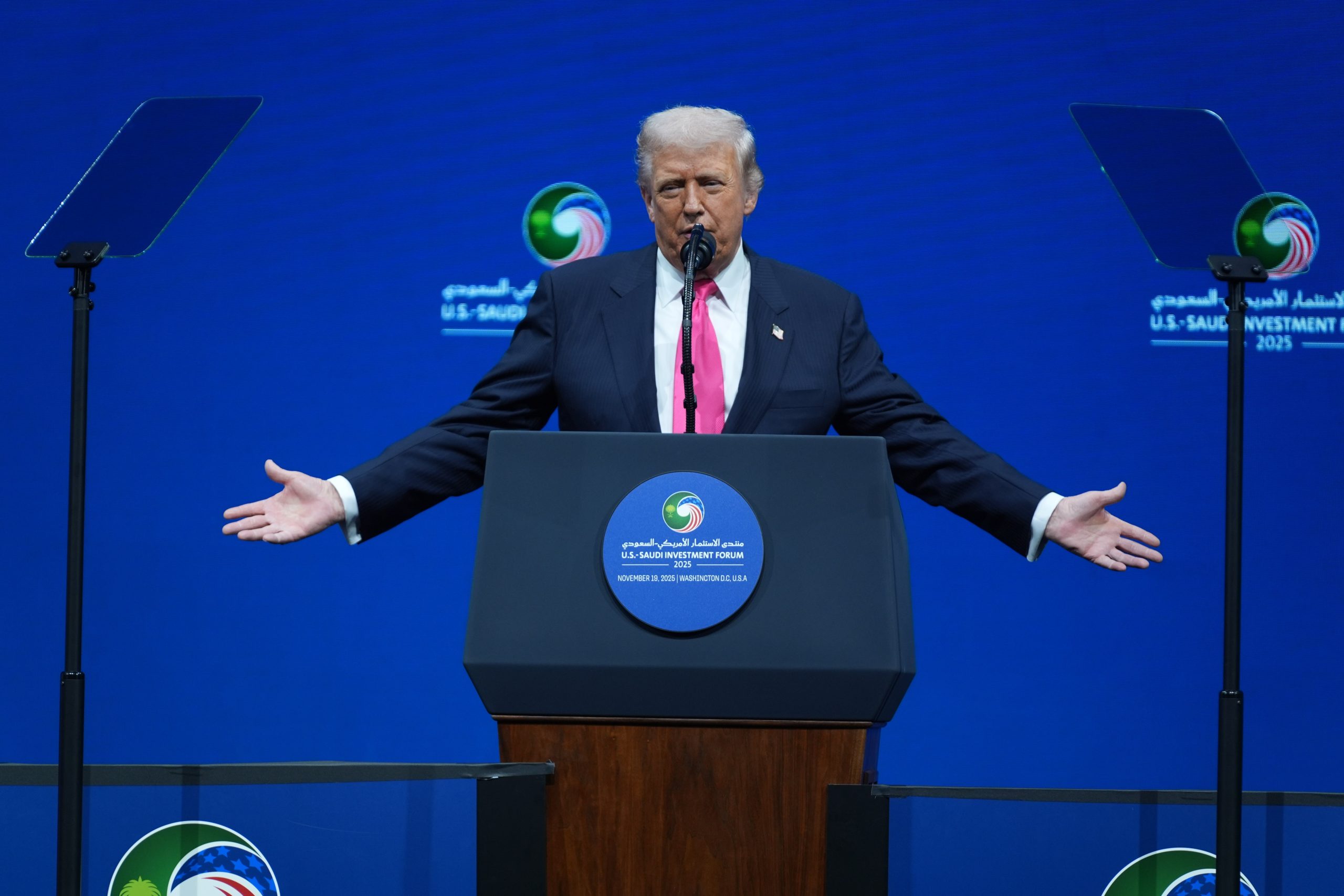 President Donald Trump giving a speech at a podium, highlighting the political context around the US economy and labor market.