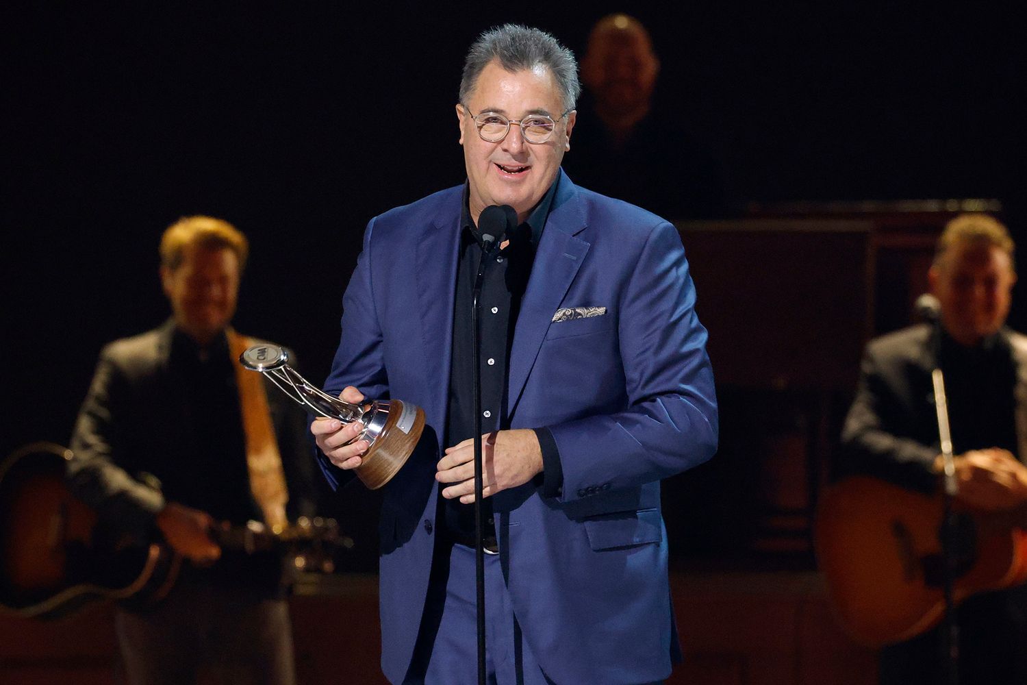 Vince Gill delivering his acceptance speech after receiving the Willie Nelson Lifetime Achievement Award at the CMA Awards, reflecting on his legacy and long-running success in country music.