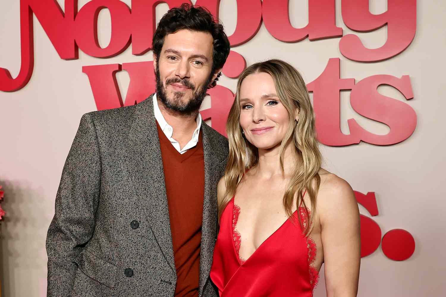 Kristen Bell and Adam Brody posing together on the red carpet at the Nobody Wants This premiere, smiling for photographers.